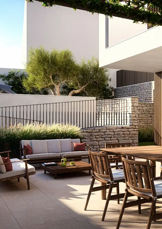 Patio esterno con divano, muri in pietra e vegetazione